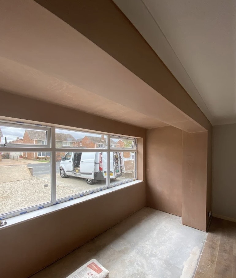 Alternate view of plaster skimming around a bay window wall and beam in SE London.